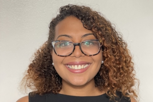 Head shot of Alexa Rodriguez smiling, wearing black top and glasses