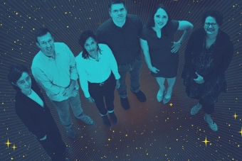 Aerial view of six researcher look up in a dark room with a starry background.